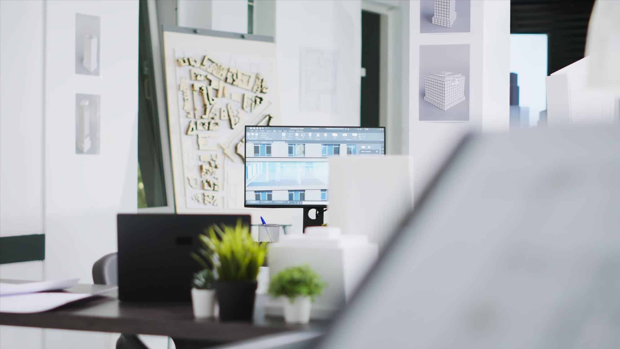 Poste de travail d'architecte: plans, maquettes et design 3D Poste de travail d'architecte: écran 3D (logiciel ArchiPlanner), maquette de ville, plans de gratte-ciels et fournitures de bureau.